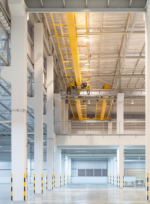 Interior of a manufacturing factory with spray foam insulation applied on ceilings and walls for enhanced energy efficiency.